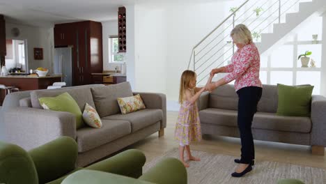 Grandmother-and-granddaughter-dancing-in-living-room-4k