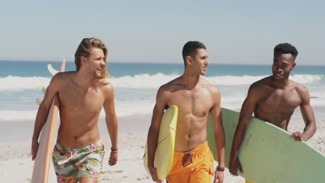hombres jóvenes en la playa llevando tablas de surf 4k