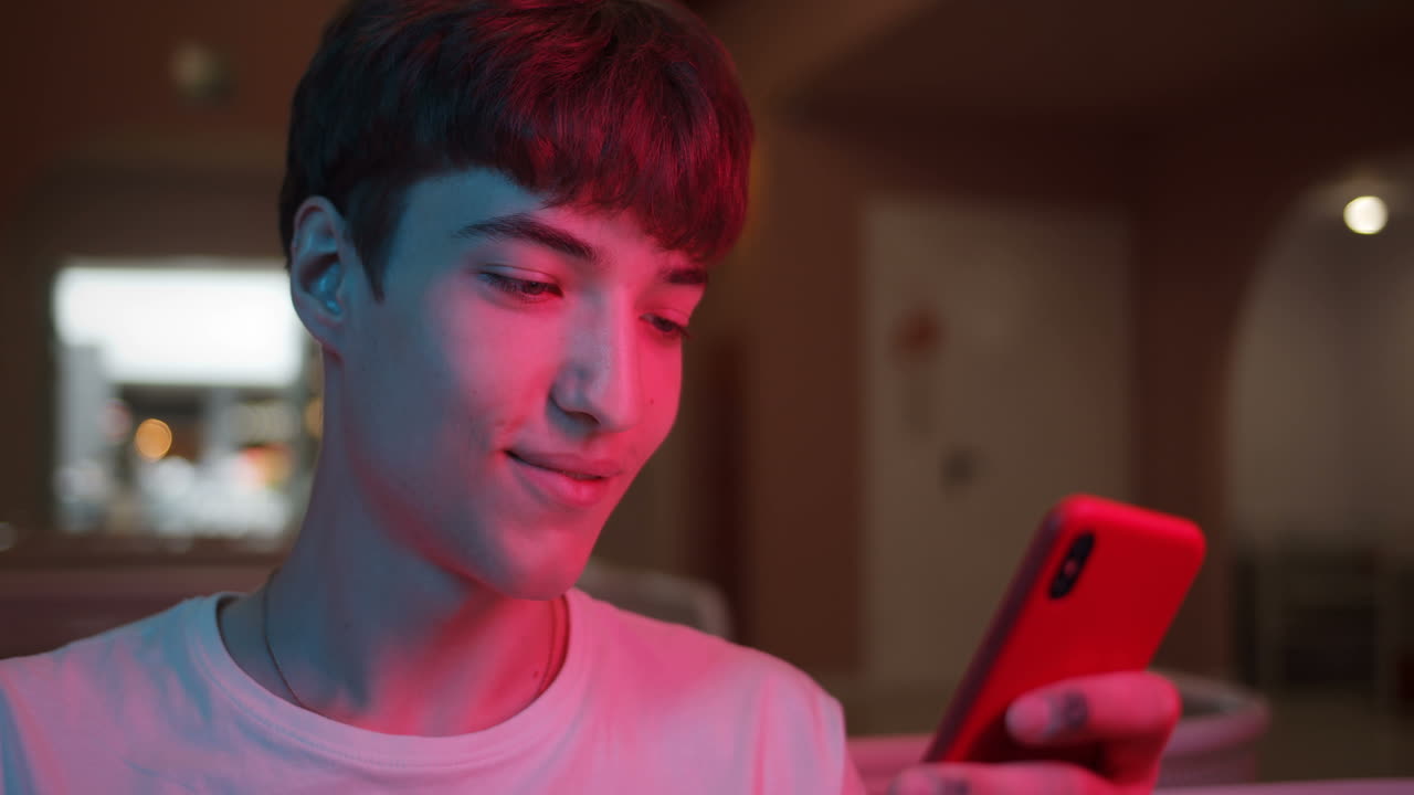 Teenager using smartphone in neon light