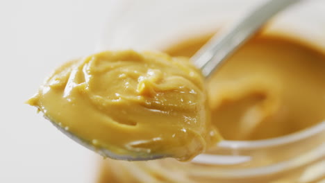 video of close up of jar of peanut butter on white background