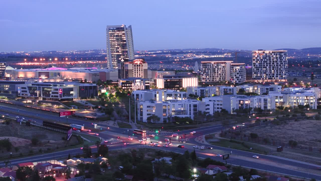 Mall of africa in midrand, south africa, with city lights at dusk, aerial view