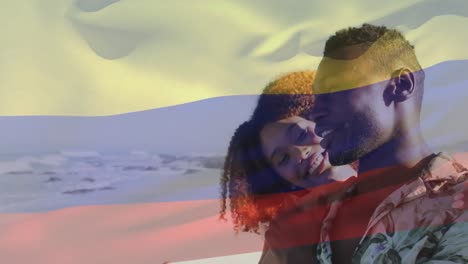 animation of flag of colombia over african american couple at beach