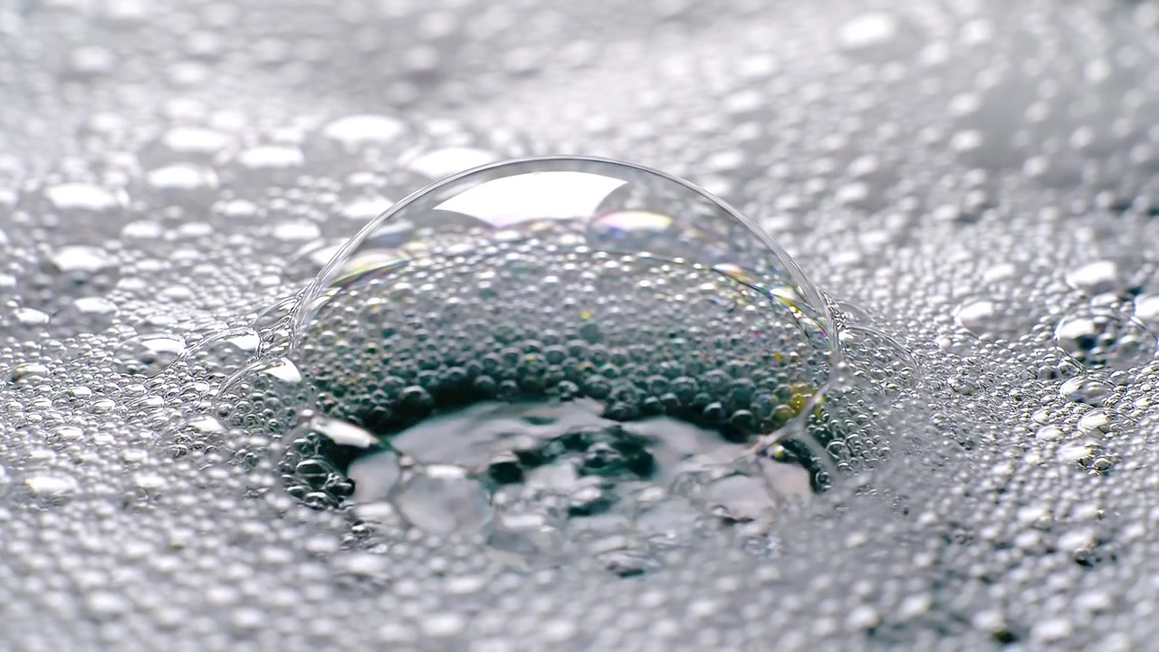 Makroansicht von Wasser, das in weiße Seifenschaumblasen fließt