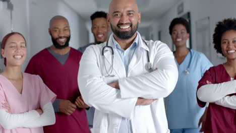 portrait of happy diverse doctors wearing lab coat and scrubs, smiling in corridor, slow motion