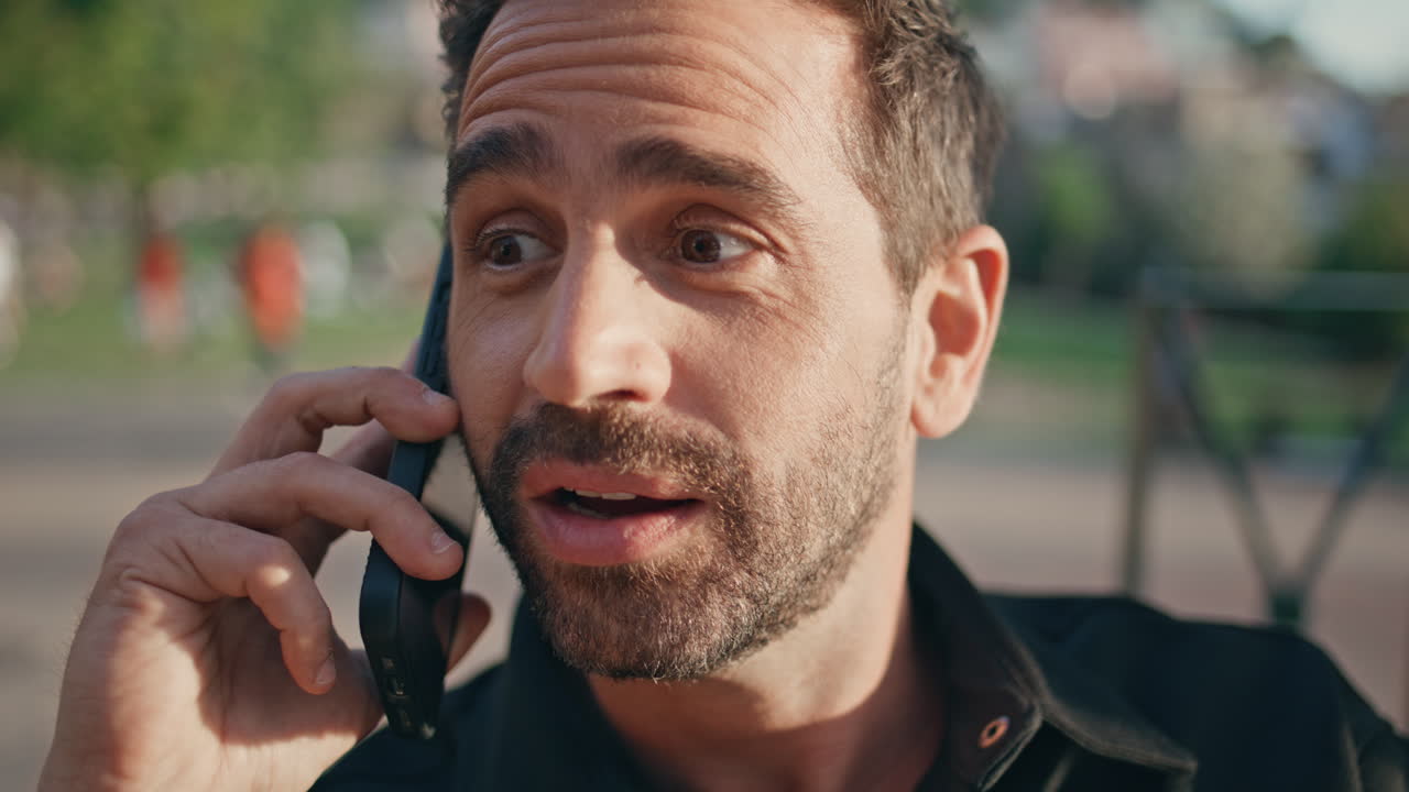 Ragazzo entusiasta parla al cellulare in città, primo piano. Uomo che fa una chiamata allo smartphone.