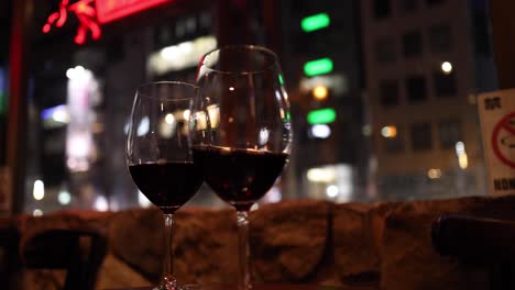 two wine glasses with cityscape bokeh background