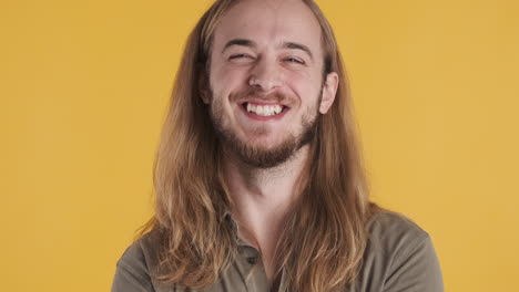 un joven caucásico sonriendo a la cámara.