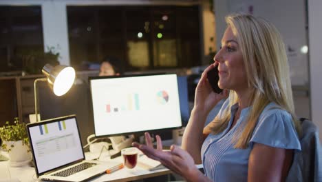 Video-De-Una-Mujer-Caucásica-Usando-Un-Teléfono-Inteligente,-Trabajando-Hasta-Tarde-En-La-Oficina