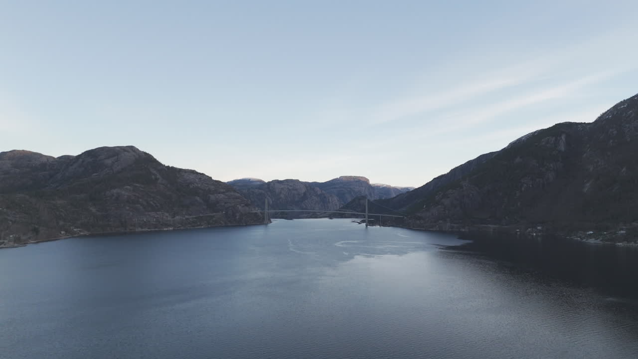Drone shot over the valley near Forsand Norway with the Bridge over Lysefjord in the background near sunset on a clear day LOG
