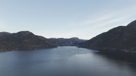 drone shot over the valley near forsand norway with the bridge over lysefjord in the background near sunset on a clear day log
