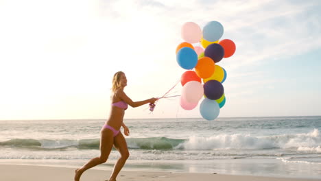 a woman is playing with the balloons