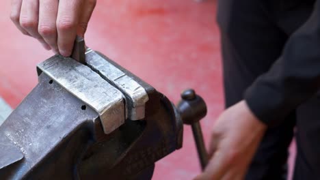 Slow-motion-shot-of-an-engineer-removing-steel-from-a-metal-vice-in-an-industry-workshop-in-Stornoway-on-the-Isle-of-Lewis,-part-of-the-Outer-Hebrides-of-Scotland