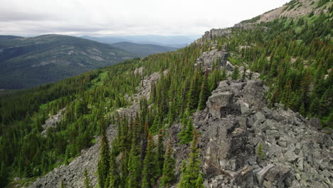 Aerial-dolly-over-jagged-ridge-with-rocky-outcrops,-mountain-wilderness