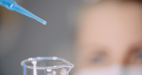 el médico gotea cuidadosamente el medicamento de la pipeta en tubos de vidrio de muestra para el análisis de adn en el laboratorio 8