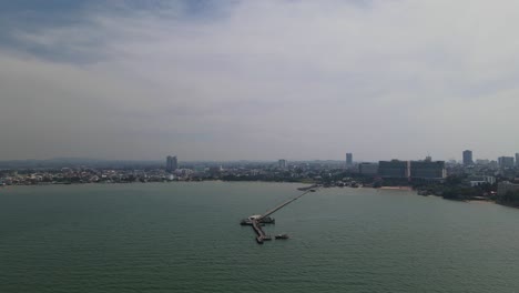 imágenes aéreas hacia un muelle con la playa y la ciudad de pattaya en el fondo, muelle de pesca de pattaya, pattaya, tailandia