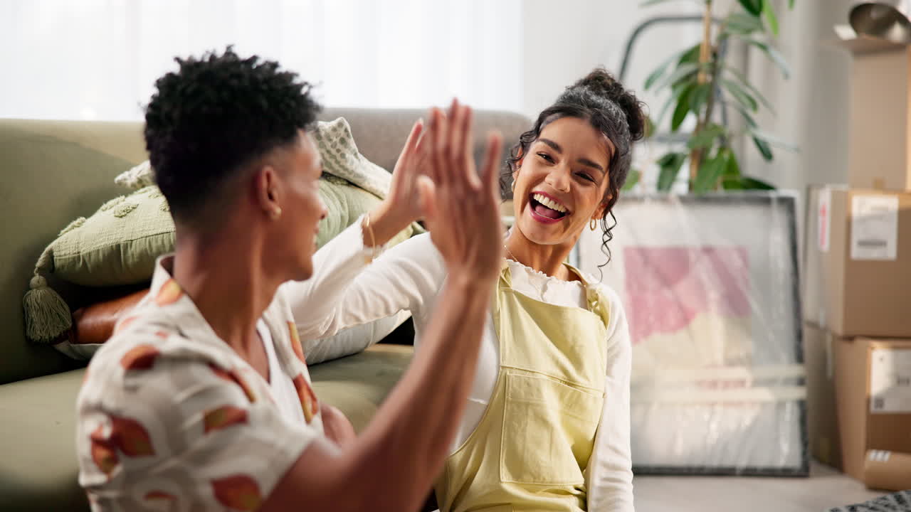 Young couple laughing while moving into a new apartment