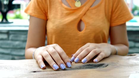 woman's fingers taping to think and snapping on table