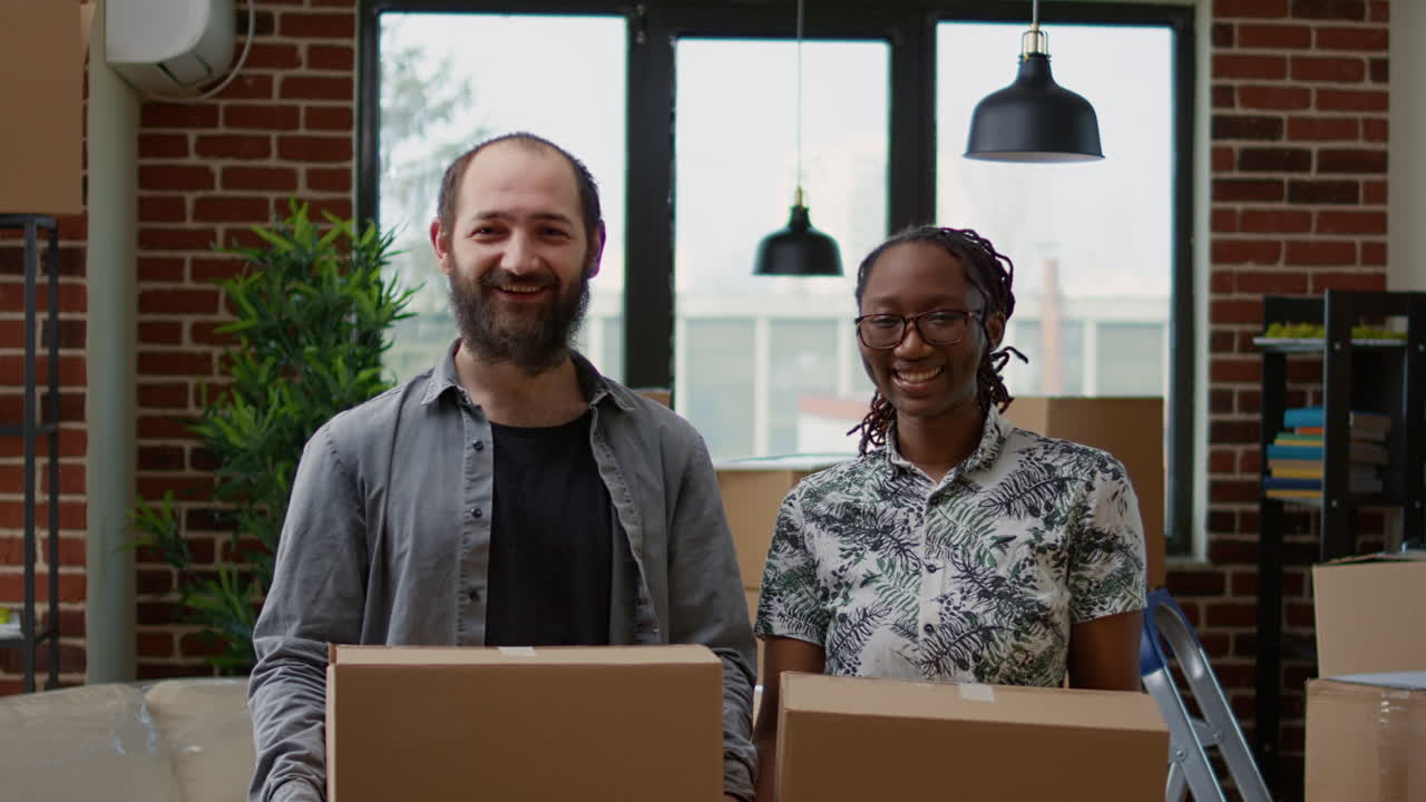 Portrait of husband and african american wife moving in together