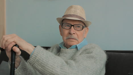 Elderly-Man-With-Gray-Mustache,-Hat,-Glasses-And-Cane