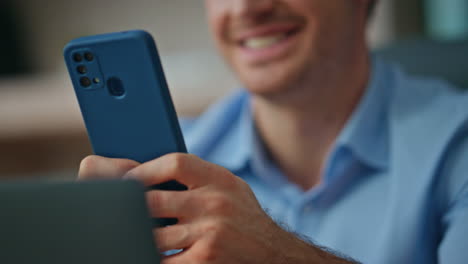 corporate manager texting mobile phone in morning office close up. smiling man