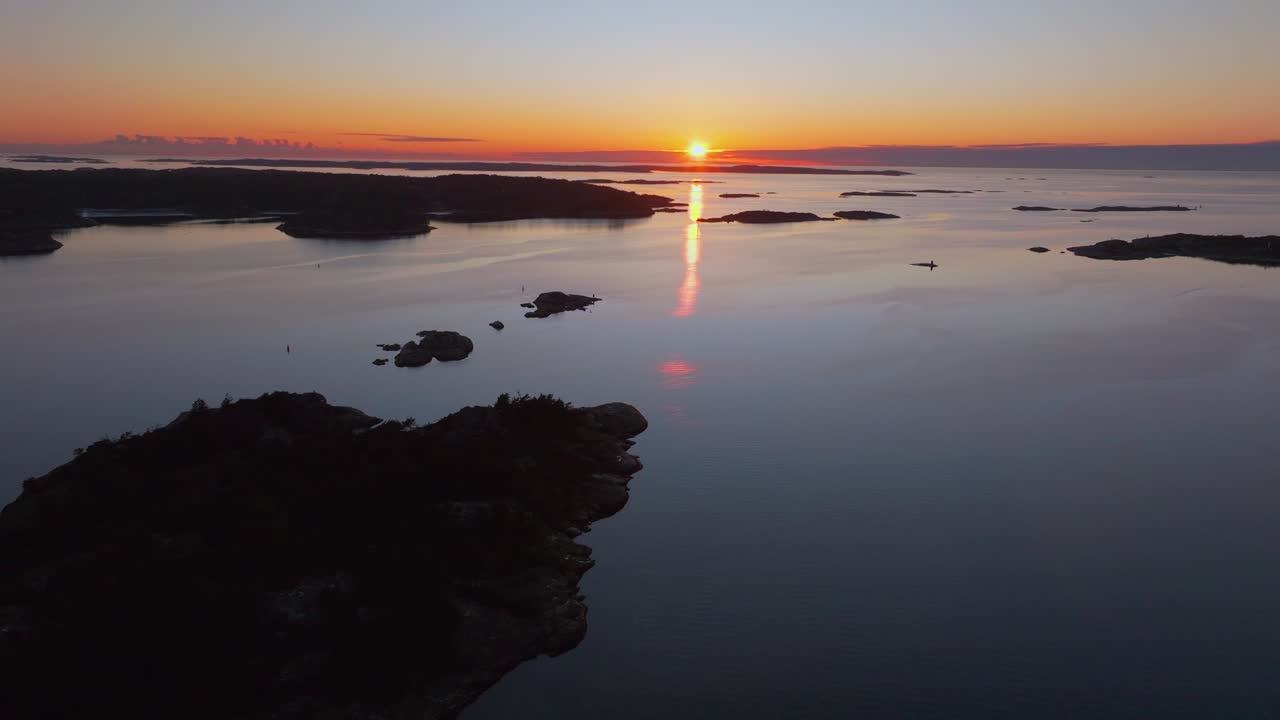 Strömstad Stromstad Sweden aerial drone Arctic Circle islands golden sunset sun on horizon peaceful calm still Sandelfjord Fjord Baltic Sea marina harbor picturesque seaside forward pan up motion