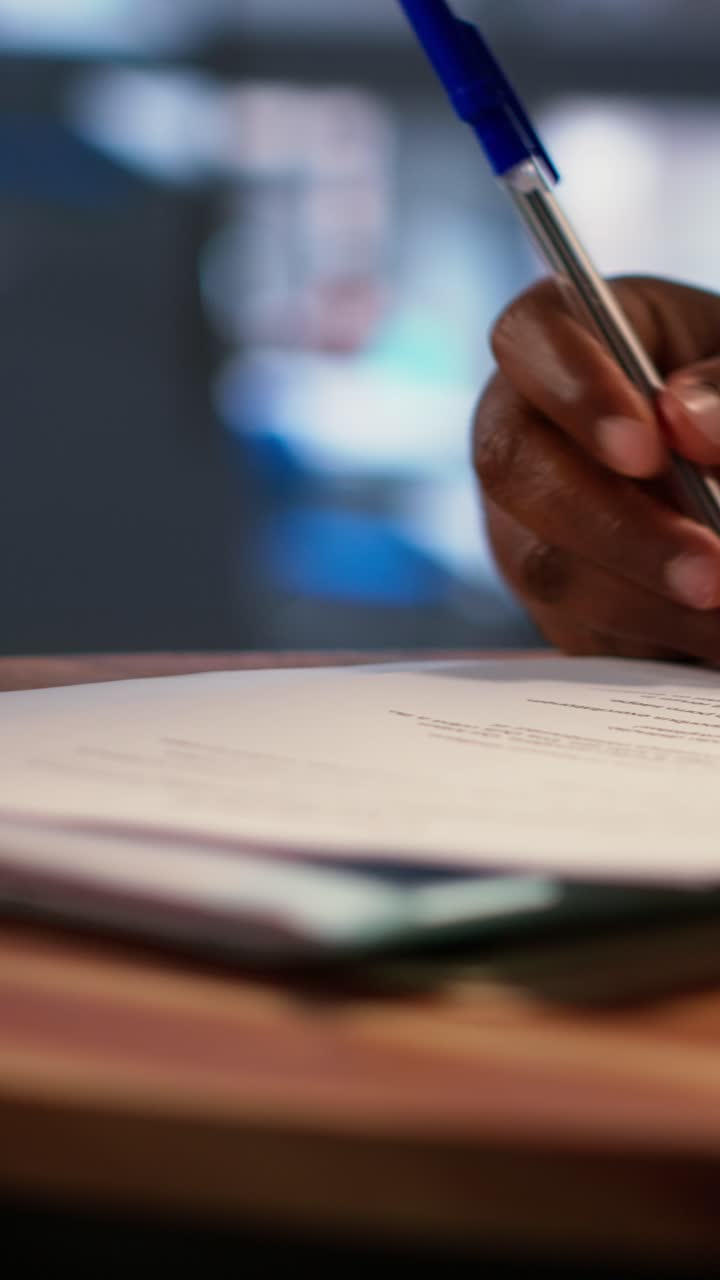 Close-up of Hand Writing on Document with Pen