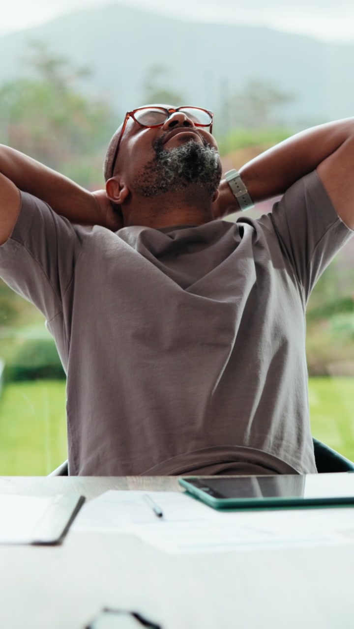 Mature Man Relaxing at Desk After Completing Work