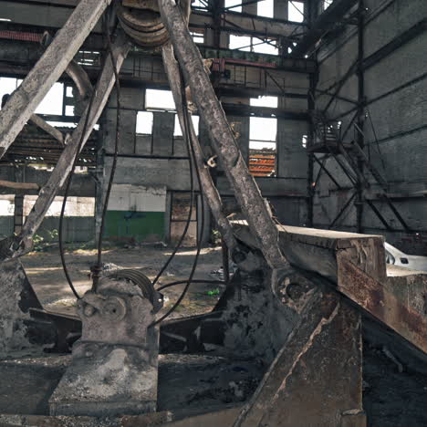 old construction with stairs and antique car frame on the background of broken plant. interior of the large abandoned building with a damaged car and metal debris.