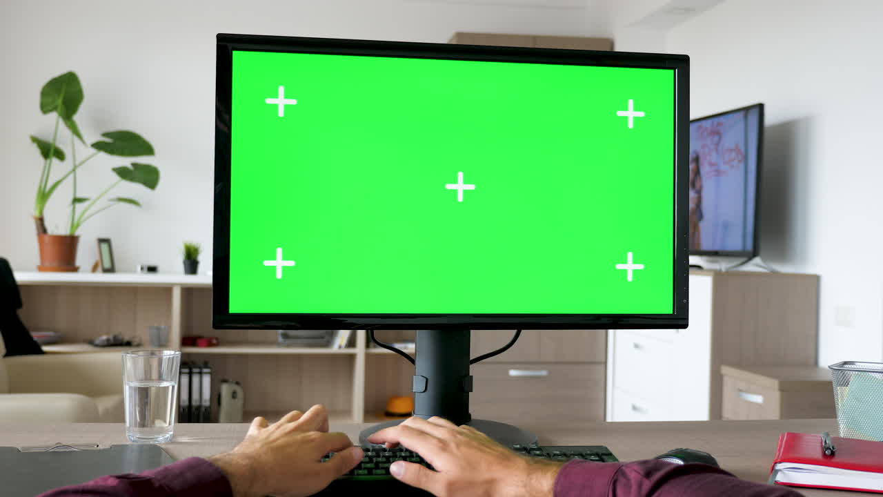 Person using computer with green screen