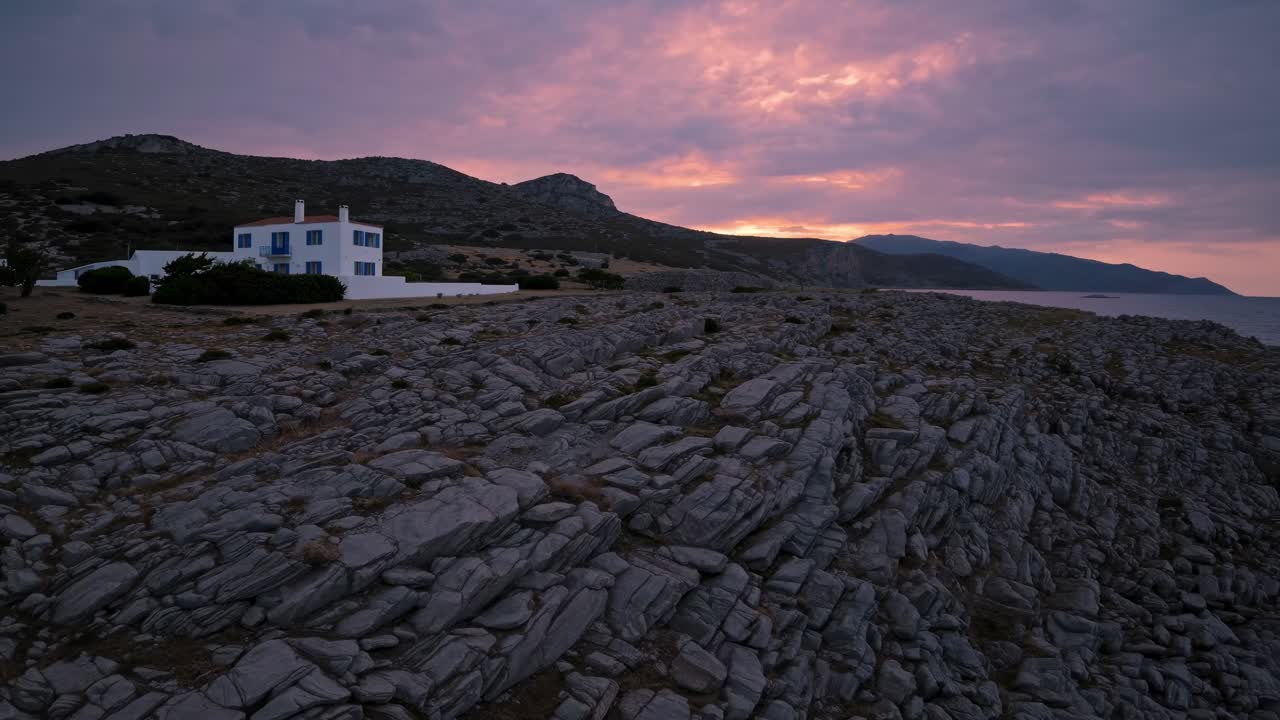 House on a rocky coastline at sunset