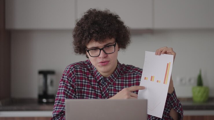 A man shows a graph in a web camera