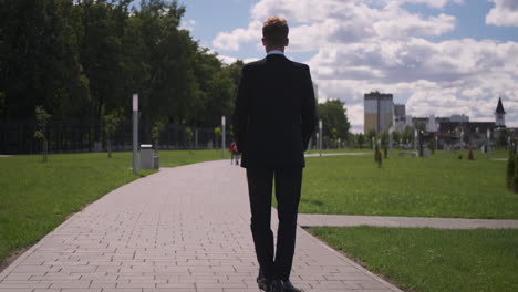 businessman walking in a park