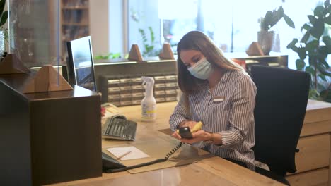 Recepcionista---Empleado-De-Oficina-Está-Limpiando-El-Lugar-De-Trabajo-Y-Desinfectando-El-Teléfono---Imágenes-De-Turismo-Covid-19