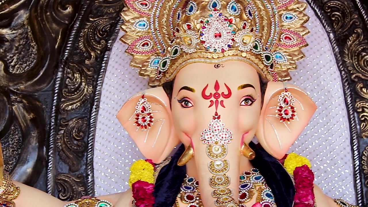 Volto dell'idolo di Ganesha con corona d'oro e orecchini durante la panoramica della celebrazione del festival Ganesh Chaturthi in India