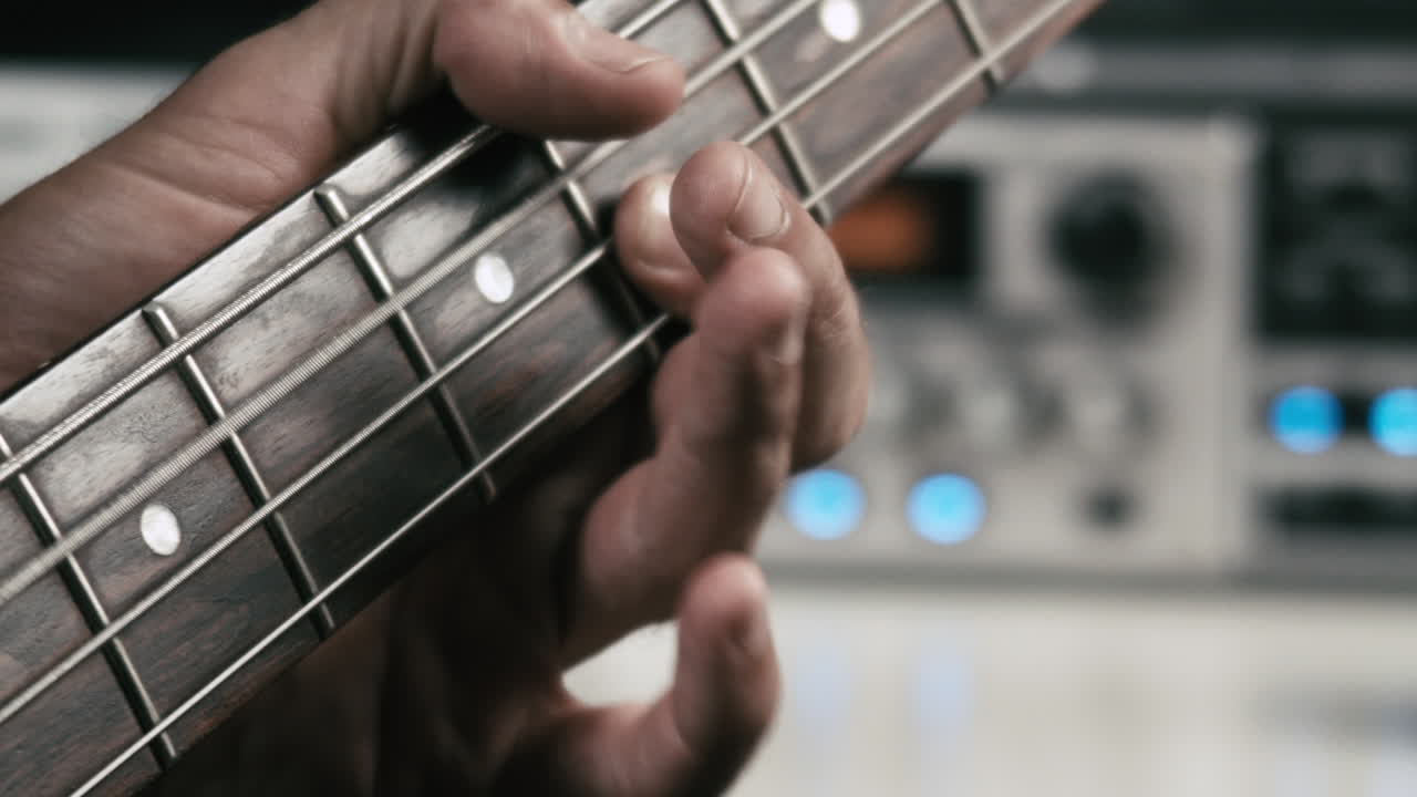 foto macro de la mano de un músico mientras toca el bajo