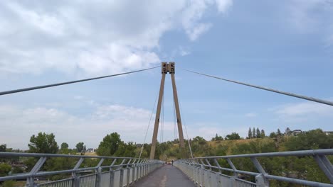 hanging bridge over river and road in park calgary alberta canada