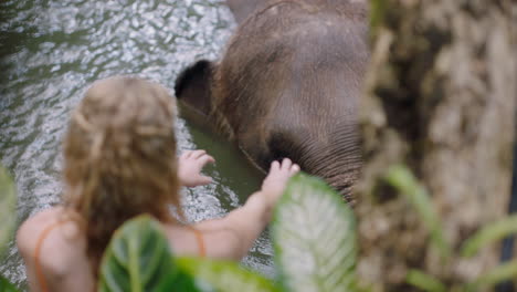 Frau-Spielt-Mit-Elefanten-Im-Zoo-Und-Sprüht-Wasser-Und-Hat-Spaß-Bei-Einem-Exotischen-Urlaub-Im-Tropischen-Waldschutzgebiet