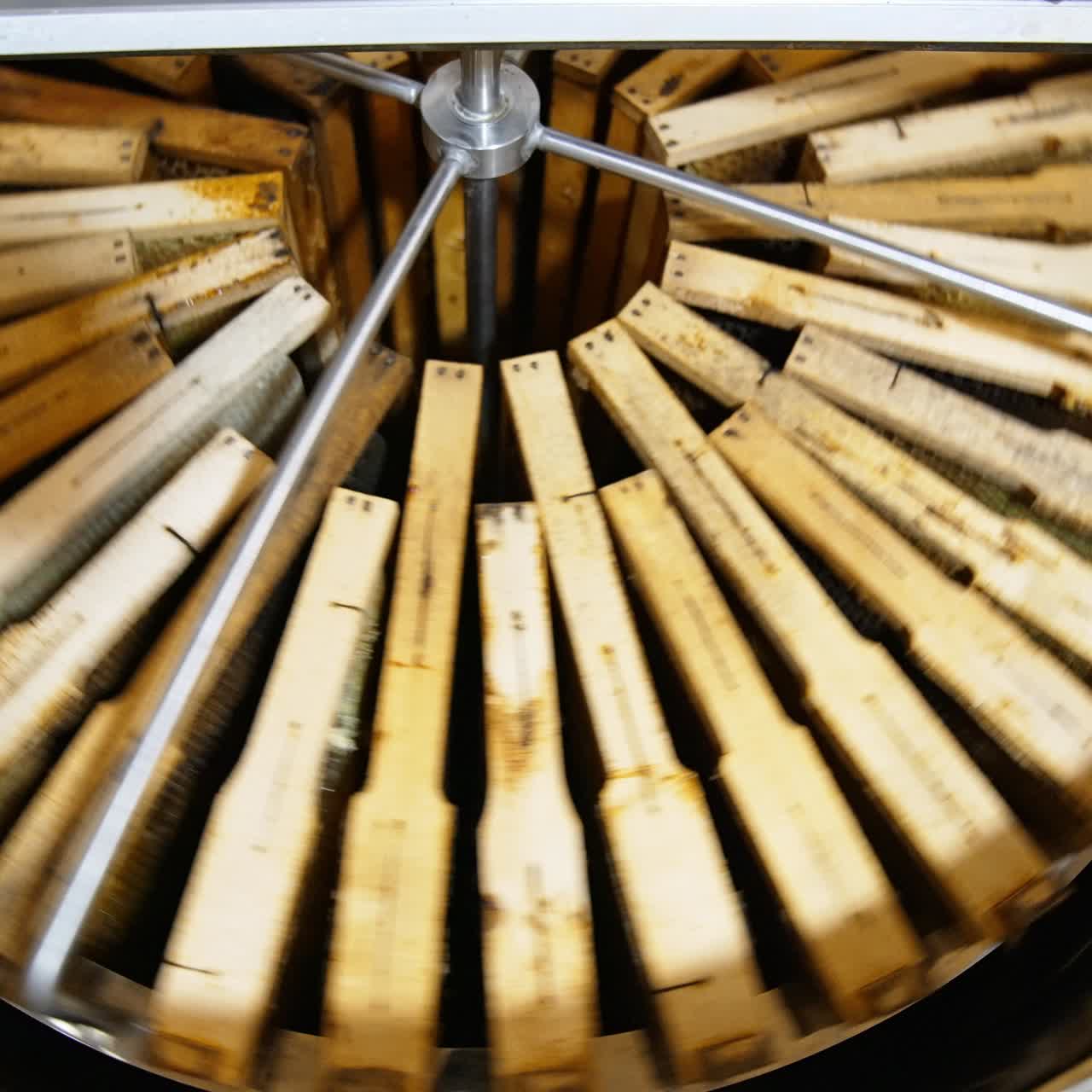 Centrifuge inside a metal barrel rotating and spinning honey frames. Extracting healthy product in special device