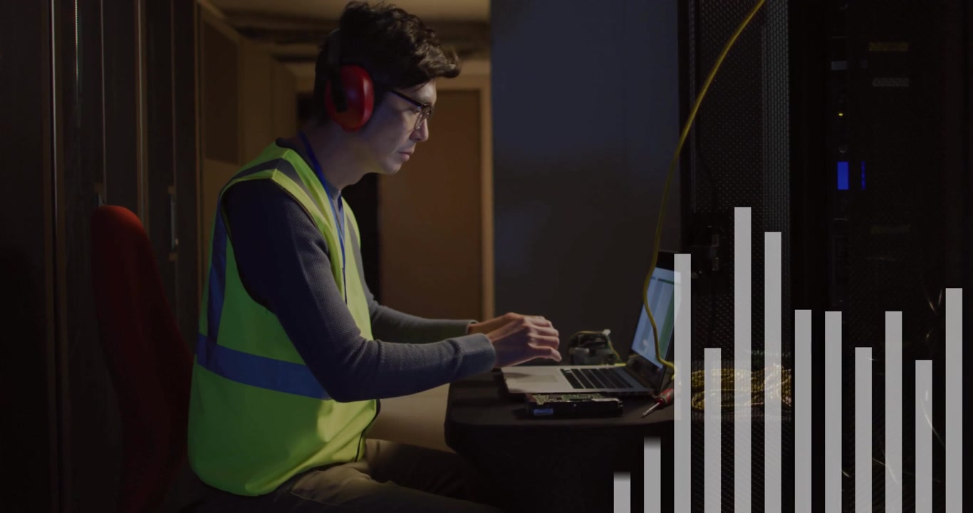 Tecnico che monitora un grafico a barre in aumento in un data center, digitando le impostazioni del server per ottimizzare il segnale.