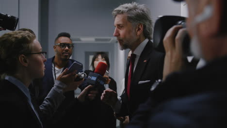 political figure being interviewed by journalists
