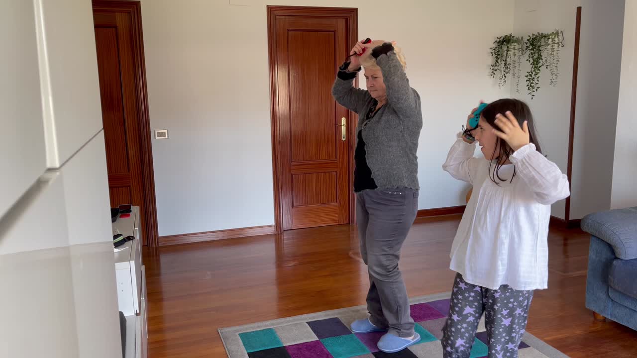 Avó e neta executando coreografia de dança na sala de estar de casa