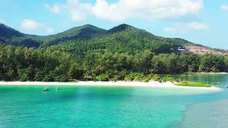 calm turquoise lagoon reflecting green vegetation of tropical island shoreline with palm trees and white sandy beach in thailand