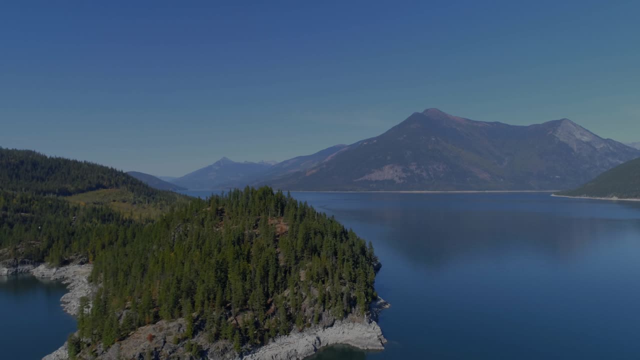 Neon line graphs appearing from left edge sweeping over peninsula and mountains, visualizing trends