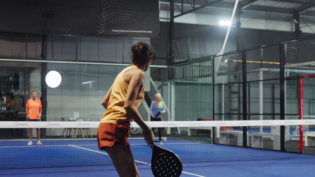 Women playing padel in an indoor court