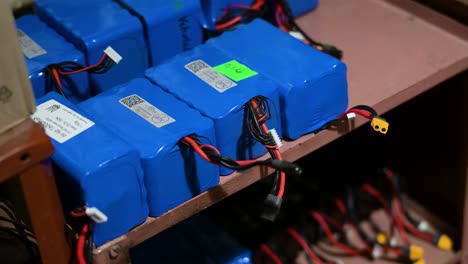powering the drone war: a stock of high-capacity lithium batteries on shelves in a ukrainian workshop, ready to be fitted into fpv drones for combat missions against russia