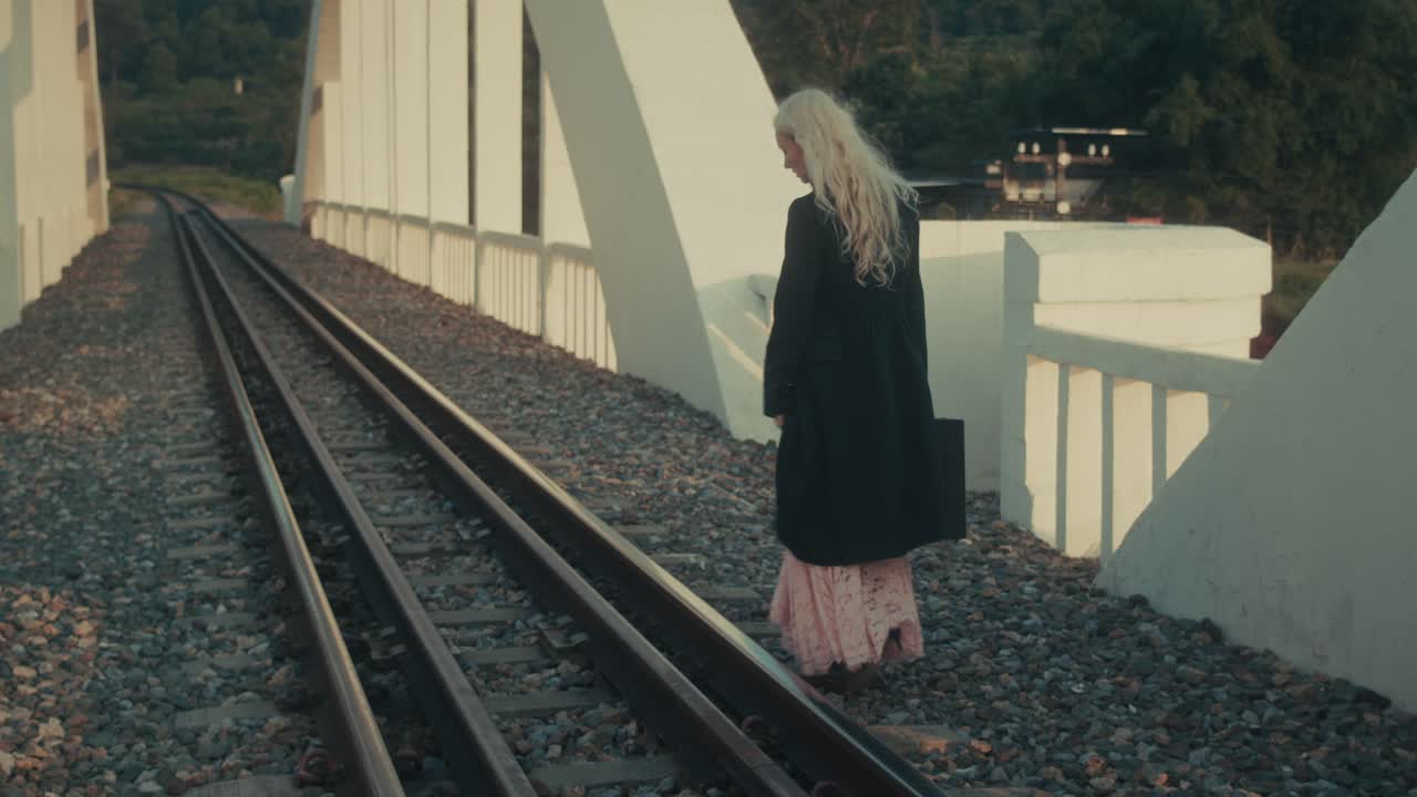 Woman Walking on Train Tracks Bridge