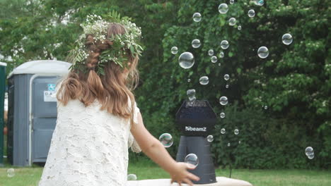 slow motion of young girl playing with bubbles