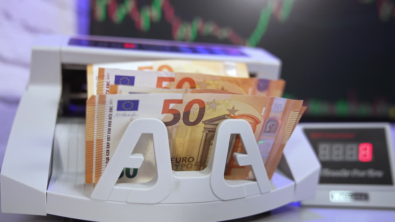 Fifty euro banknotes counting in bank. Electronic counting machine doing calculations of paper money. Man's hand taking out counted euro bills.