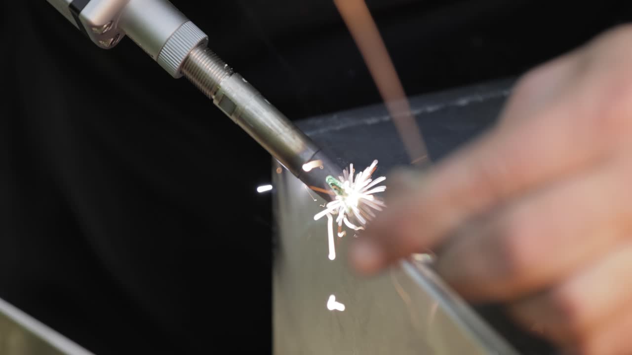 손잡이 총을 가진 레이저 용접 기계. 레이저 용접은 클로즈업으로 표시됩니다.