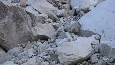footage featuring a tilt-down shot of giant granite boulders nestled within the rugged terrain of yosemite national park, california.
